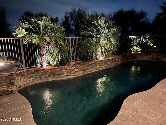 pool at twilight featuring an outdoor pool and fence