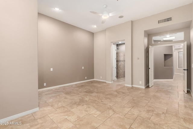 empty room with a ceiling fan, visible vents, and baseboards