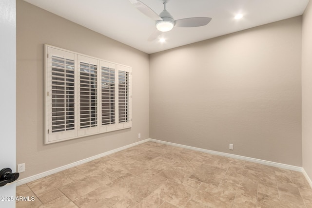 spare room featuring baseboards and a ceiling fan