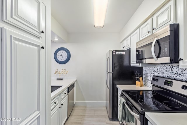 kitchen featuring light stone countertops, appliances with stainless steel finishes, tasteful backsplash, and white cabinetry