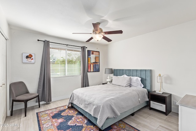 bedroom with ceiling fan, a closet, and light hardwood / wood-style floors