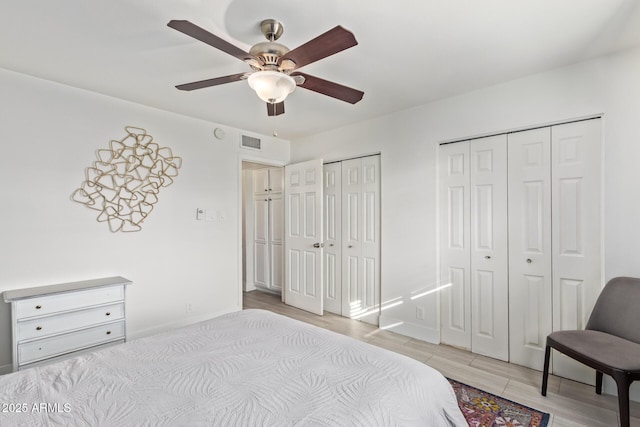 bedroom featuring ceiling fan and two closets