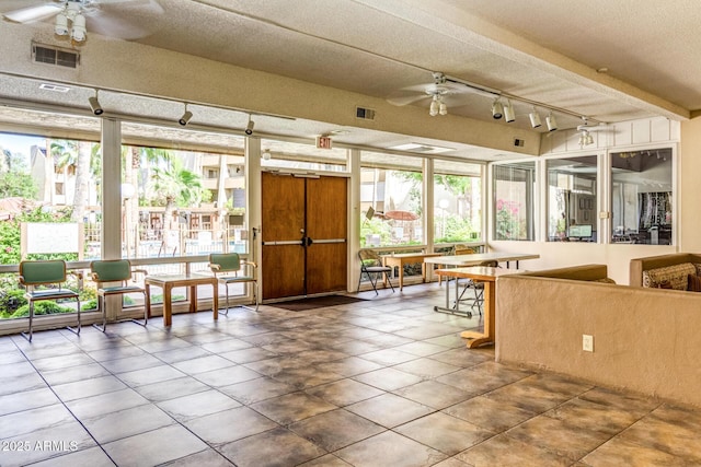 unfurnished sunroom with ceiling fan and track lighting