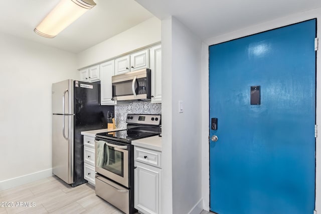 kitchen featuring decorative backsplash, stainless steel appliances, and white cabinetry