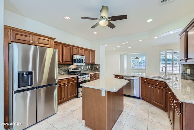 kitchen featuring backsplash, appliances with stainless steel finishes, sink, and kitchen peninsula