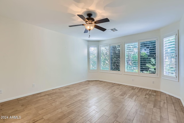 empty room with light hardwood / wood-style flooring, ceiling fan, and plenty of natural light