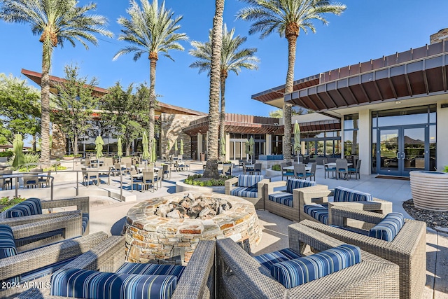 view of patio with an outdoor living space with a fire pit