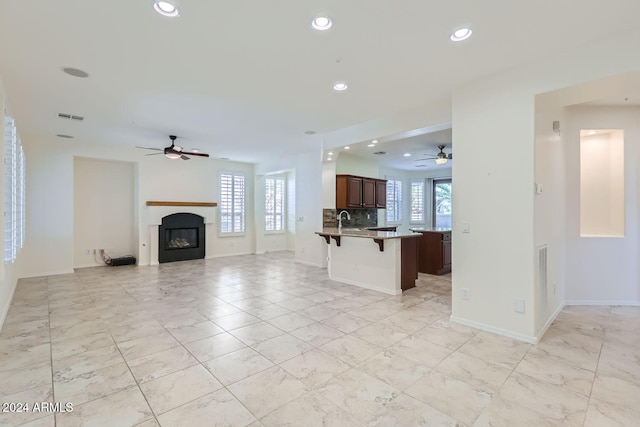 unfurnished living room with sink and ceiling fan