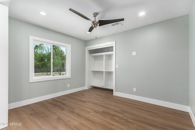 unfurnished bedroom featuring hardwood / wood-style floors, ceiling fan, and a closet