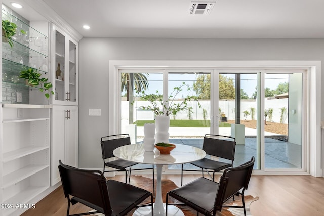 dining space featuring built in features, a healthy amount of sunlight, and wood-type flooring