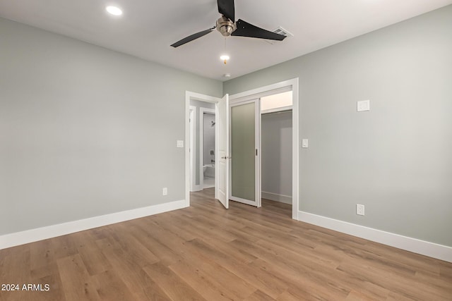 unfurnished bedroom featuring ceiling fan, a closet, and light hardwood / wood-style flooring