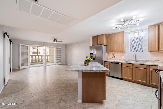 kitchen with ceiling fan, stainless steel appliances, sink, and backsplash