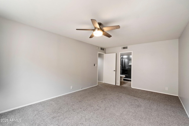 unfurnished bedroom with dark colored carpet, ceiling fan, and ensuite bathroom