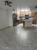 kitchen featuring stainless steel appliances, tasteful backsplash, a kitchen island, and ceiling fan