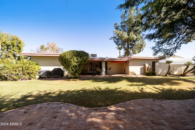 rear view of property with a patio area and a lawn