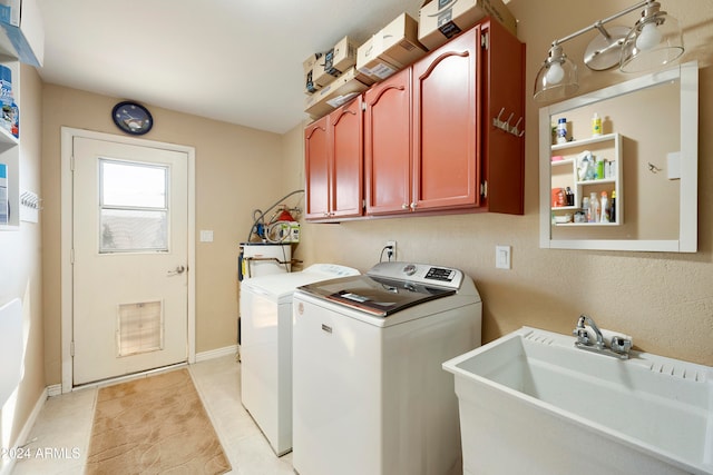 laundry area featuring cabinets, light tile patterned flooring, sink, and washing machine and dryer