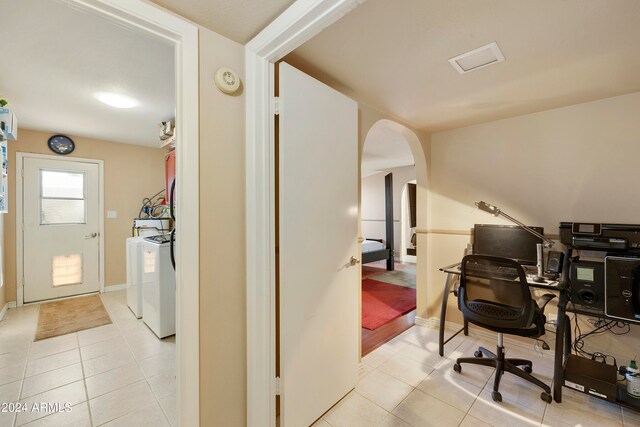 office area featuring light tile patterned flooring and washing machine and clothes dryer