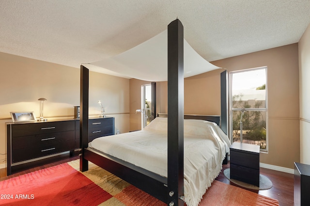 bedroom with a textured ceiling and wood-type flooring