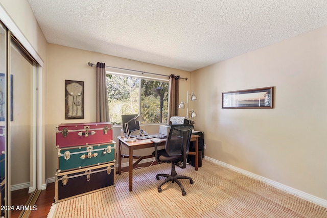 office area featuring a textured ceiling and light hardwood / wood-style floors