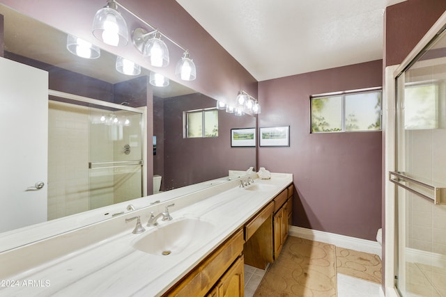 bathroom featuring vanity, a shower with shower door, toilet, and tile patterned floors