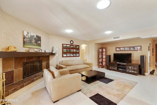 tiled living room featuring a textured ceiling and a fireplace