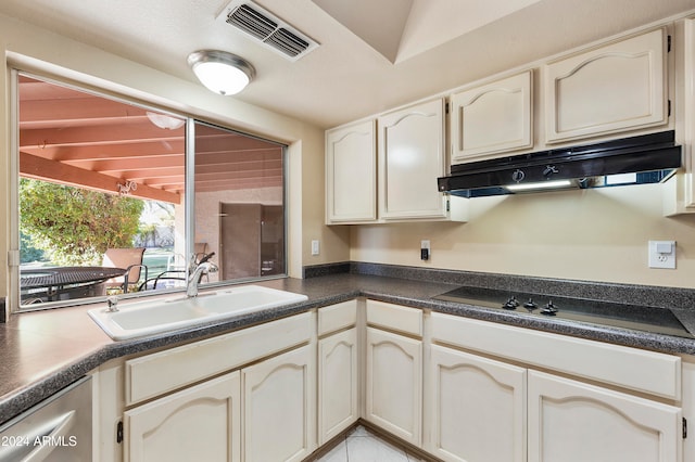 kitchen with light tile patterned flooring, lofted ceiling, sink, and stovetop