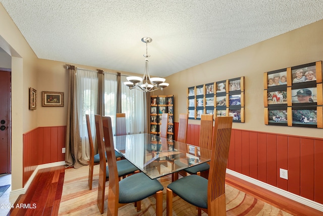 dining room featuring a chandelier, a textured ceiling, and light hardwood / wood-style floors