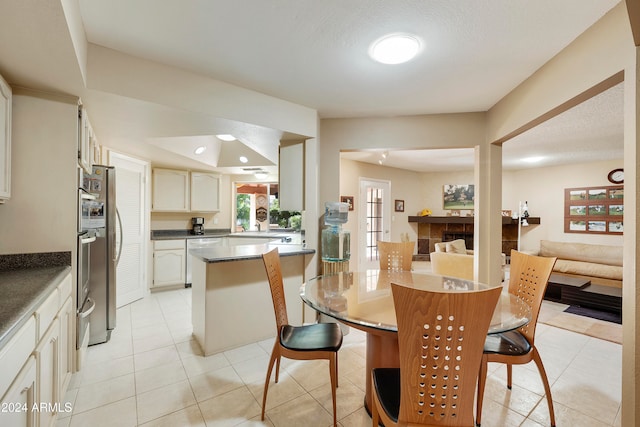 dining space featuring light tile patterned flooring and a textured ceiling