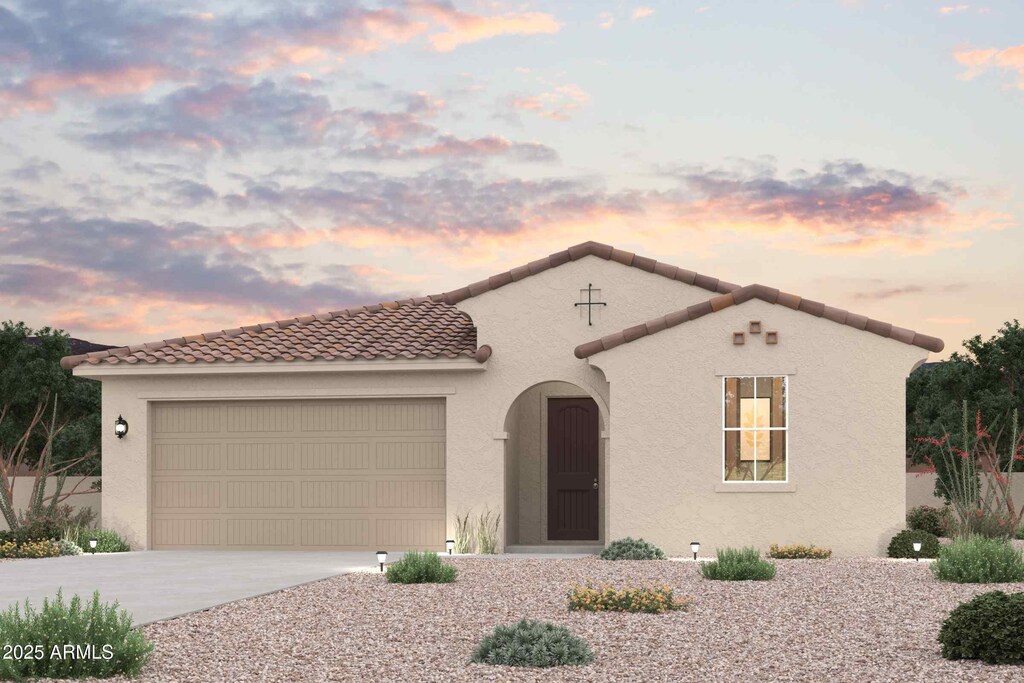mediterranean / spanish-style home with stucco siding, a tile roof, a garage, and concrete driveway