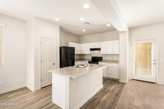 kitchen featuring a center island with sink, sink, black appliances, white cabinets, and light hardwood / wood-style floors