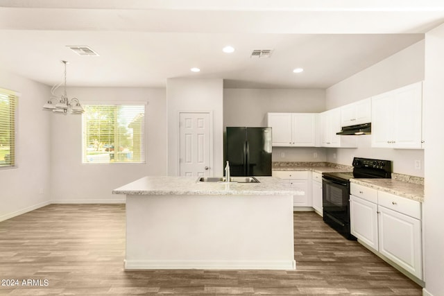 kitchen featuring a center island with sink, black appliances, white cabinetry, and hardwood / wood-style flooring