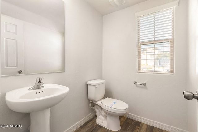 bathroom with hardwood / wood-style flooring, toilet, a healthy amount of sunlight, and sink