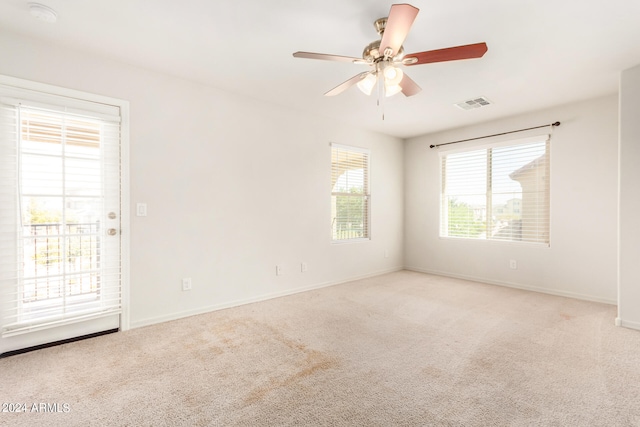 spare room featuring light carpet and ceiling fan