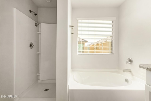 bathroom with vanity and shower with separate bathtub