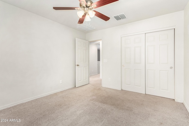 unfurnished bedroom with light colored carpet, a closet, and ceiling fan