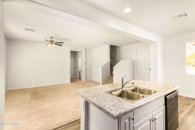 kitchen with dishwasher, an island with sink, light hardwood / wood-style flooring, sink, and ceiling fan