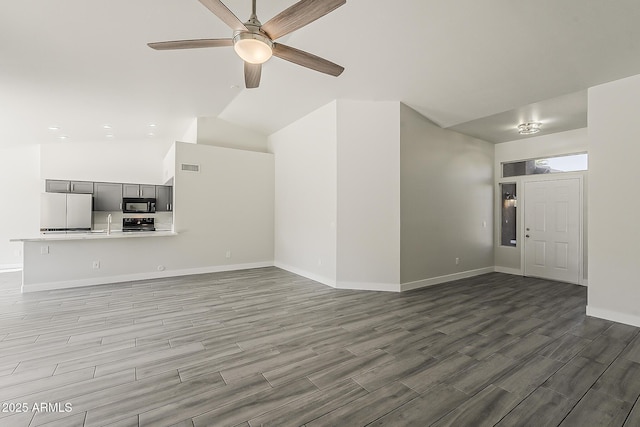 15360 N 87th Ave, Peoria, AZ 85381 - unfurnished living room featuring a ceiling fan, baseboards, wood finished floors, a sink, and high vaulted ceiling