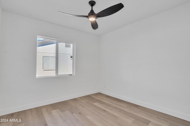 empty room with ceiling fan and light hardwood / wood-style flooring