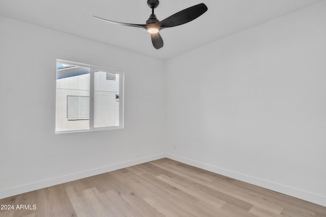 empty room with ceiling fan and light hardwood / wood-style flooring