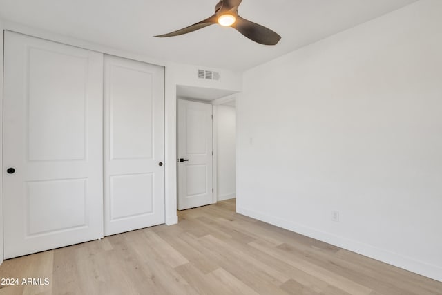 unfurnished bedroom with ceiling fan, light hardwood / wood-style floors, and a closet