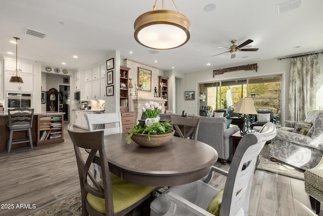 dining space with light hardwood / wood-style floors and ceiling fan