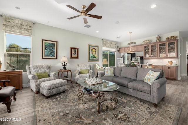 living room featuring ceiling fan, a healthy amount of sunlight, and hardwood / wood-style flooring