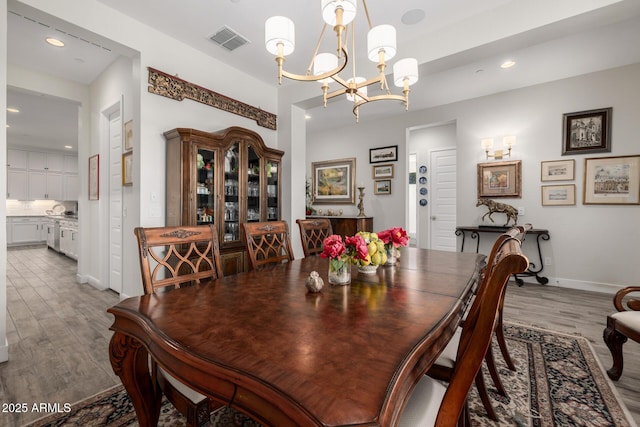 dining area with hardwood / wood-style flooring and a notable chandelier