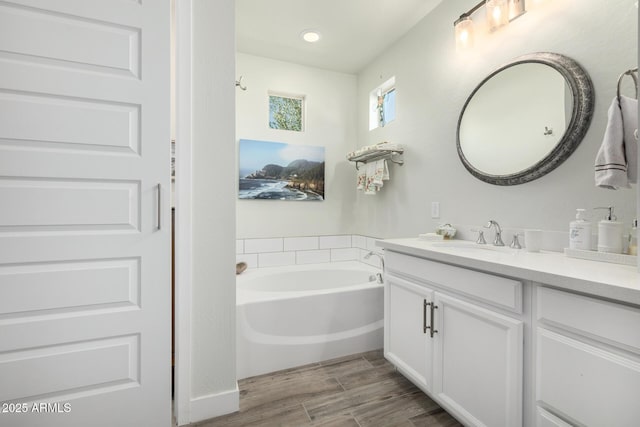 bathroom featuring a washtub and vanity