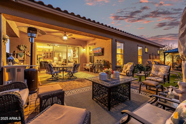 view of patio with ceiling fan and an outdoor fire pit