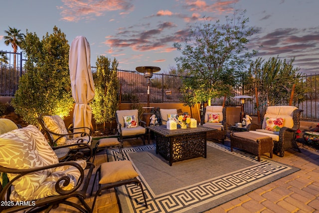 patio terrace at dusk featuring an outdoor living space with a fire pit