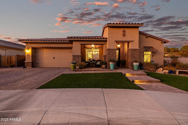 mediterranean / spanish house featuring a yard and a garage