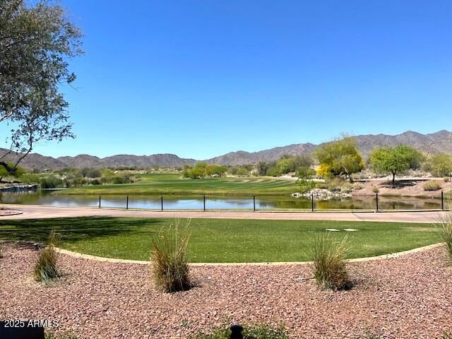 view of property's community with a lawn and a water and mountain view