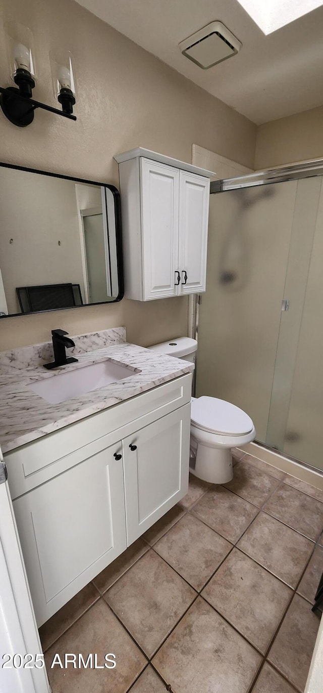 bathroom featuring visible vents, toilet, a stall shower, vanity, and tile patterned floors