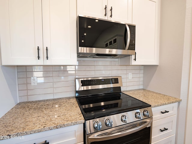 kitchen with light stone counters, white cabinetry, appliances with stainless steel finishes, and tasteful backsplash